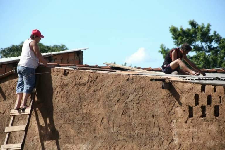 Moradores fazem manutenção em telhados. (Foto: Marcos Ermínio)