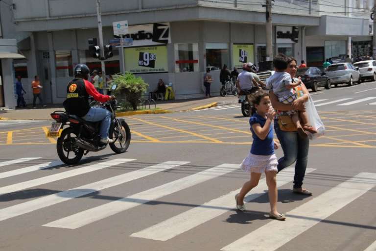 Com crianças, mulher se apressa para passar a rua e não ser atingida por carros. (Foto: Marcos Ermínio)
