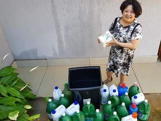 Elizabeth Yurico mostra seu sabão caseiro e a coleta da água da chuva, que ela distribui em pequenos galões para molhar plantas. Economia de 30% na conta. (Foto: Anahi Gurgel)
