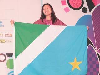 Karoline segura a bandeira de MS no pódio dos Jogos Escolares (Foto: Fundesporte/Divulgação)