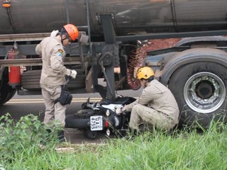 Motocicleta ficou presa embaixo do caminhão tanque (Foto: Saul Schramm)