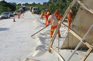 Trabalhadores da CCR removem a ureia que ficou espalhada na pista (Foto: Alcides Neto)