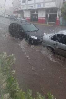 Água da chuva chegou na altura das rodas dos veículos dificultando o trafego no centro da Capital. (Foto: Leitora Regiane Dutra)