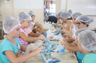 Crianças embalam doces para colocar dentro dos ovos (Foto: Fernando Antunes)