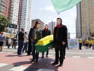 Com caix&atilde;o verde-amarelo e cela, grupo protesta contra STF ap&oacute;s desfile