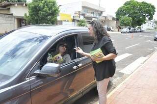 Ivanise Rotta entrega panfleto educativo para mãe em frente ao colégio Maria Montessori. (Foto:Marcelo Calazans) 