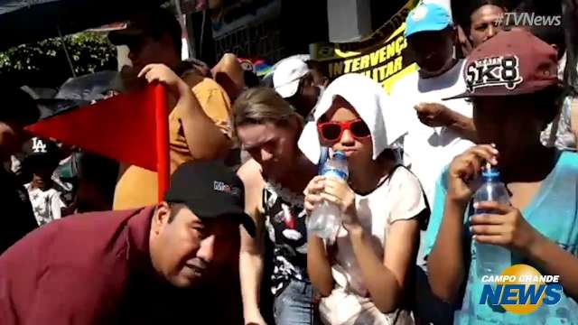 Com tempo quente e seco, p&uacute;blico leva sombrinha e &aacute;gua para desfile