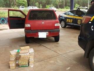 Tabletes de cocaína em frente ao carro ocupado por casal (Foto: PRF)