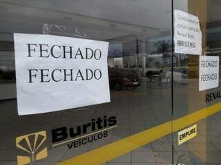 Cartaz informava clientes que concessionária estava fechada (Foto: Ricardo Campos Jr.)