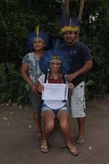 Ao lado dos pais na aldeia Limão Verde, segurando o diploma. (Foto: Dionedison Terena)