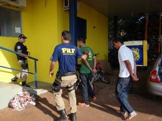 Acompanhados por policiais rodoviários, os dois rapazes presos com maconha chegam à delegacia da PRF em Dourados (Foto: Osvaldo Duarte/Dourados News)