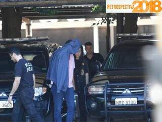 Acusado de ser “laranja” de narcotraficante, homem preso na Capital esconde o rosto ao chegar à sede da PF (Foto: Saul Schramm)