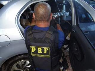 Policial rodoviário retira tabletes de maconha de Gol apreendido ontem à noite após perseguição por 50 km na BR-163 (Foto: Osvaldo Duarte/Dourados News)