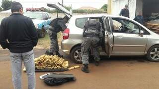 Policiais retiram tabletes de maconha de Honda Fit (Foto: Divulgação/PM)