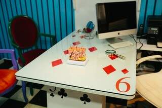Cartas de baralho formam a mesa e compõem também os armários.