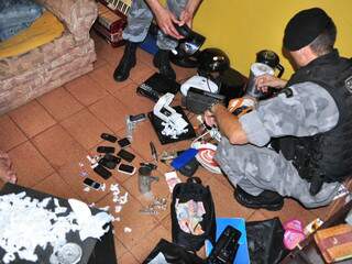 Policial confere produtos supostamente trocados por droga em casa de traficante. (Foto: João Garrigó)