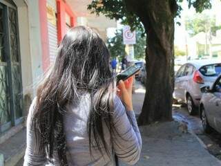 Mulher fala ao celular no Centro de Campo Grande (Foto: Arquivo/Marina Pacheco)