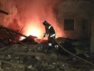 Militar combate incêndio em escombros de loja (Foto: divulgação/Corpo de Bombeiros)
