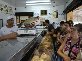 Vendedor mostrando exemplar de pescado (Foto: Fernando da Mata)