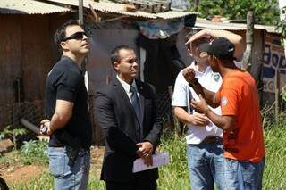 Morador conversa com agentes da Polícia Civil sobre gato na favela (Foto: Marcos Ermínio)