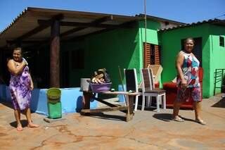 Madalena e Maria ao lado dos móveis, roupas e outros itens, que precisaram ficar ao sol hoje (19) para secar. (Foto: Marcos Ermínio)
