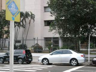 Dois carros estacionam na faixa, bem ao lado da placa que pede respeito ao pedestre. (Foto:Repórter News)