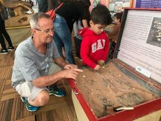Breno e o neto Mateus de 4 anos se divertiram com a escavação de uma réplica de esqueleto humano (Foto: Ronie Cruz)