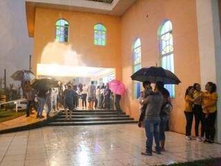 Féis se protegendo da chuva durante apresentação na Capela São Pedro e São Paulo (Foto: Paulo Francis) 