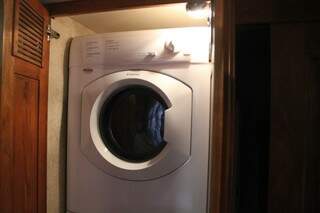 Armários escondem no quarto as máquinas de lavar e de secar roupas. 