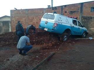 Moradores tentam ajudar a retirar veículo preso em parede (Foto: Mirian Machado)