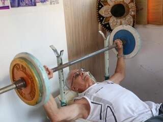 João Sidney Figueiredo tem 80 anos e treina levantando pesos na academia que tem em casa (Foto: Paulo Francis)