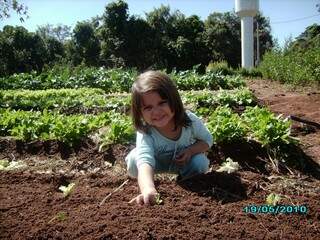A filhinha de Vaceila ajudando no plantiu das mudinhas na horta (Foto: Divulgação)
