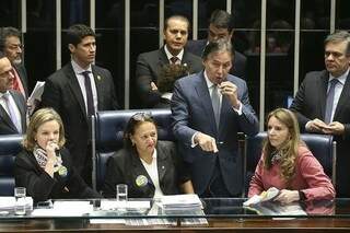 Senadoras que protestaram contra a reforma ocupando a mesa; no microfone, o presidente do Senado, Eunício de Oliveira (PMDB-CE) (Foto: Antônio Cruz/Divulgação)