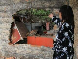 Dona de casa mostra parede quebrada pelos bombeiros para facilitar na ocorrência de incêndio (Fotos: Marina Pacheco)
