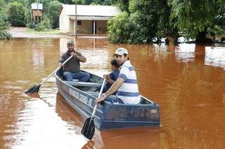 No Barreirão, moradores usaram barco para sair de casa após chuva de quinta-feira (Foto: Eliel Oliveira)