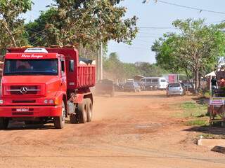 Poeira levanta com passagem de caminhões em rua de terra no Rita Vieira III. (Fotos: João Garrigó)