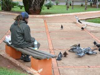 Thiago dividiu o pão com os pombos da praça (Foto: Minamar Júnior)