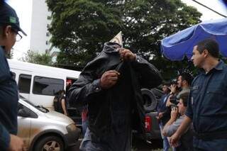 Primeira fase da Oiketicus foi deflagrada em maio. Na foto, policial esconde o rosto ao chegar à Corregedoria da PM(Foto: Fernando Antunes/Arquivo)