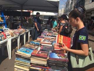 Lojistas montaram bancas para vender produtos com descontos de até 30% e Elaine aproveitou para comprar livros (Foto: Guilherme Henri)
