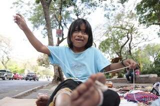 Ao mesmo tempo, tem as origens do povo paraguaio nas ruas, como a menina fazendo artesanato na praça.