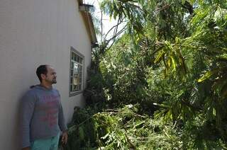 Lincoln de Souza conta que acionou os bombeiros mas a árvore caída continua em seu quintal. (Foto:Marcelo Calazans)