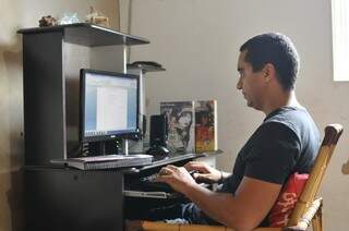 No computador ele escreve os capítulos, focado na história que criou. (Foto: Alcides Neto)