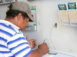 Apostador marcando os números da sorte em lotérica. (Foto: Marina Pacheco)