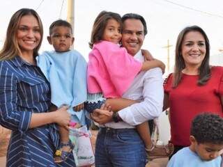 Primeira-dama, prefeito e vice posam em foto com crianças que ganharam ponche na ação (Foto: Divulgação/PMCG)