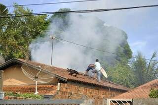 Homens destelharam casa para ajudar no combate ao fogo. (Foto: Marcelo Calazans)