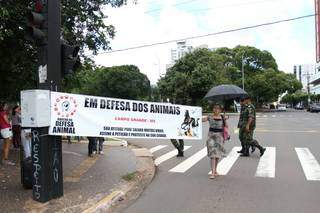 Protetora de animais segurando faixa em protesto na Afonso Pena (Foto: Saul Schramm)