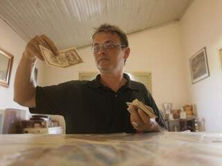 Ivanilson mostrando suas cédulas do passado. Ele tem coleção com milhares de exemplares. (Foto: João Paulo Gonçalves)