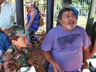 Avô, à direita, contando paixão do neto com o Exército. (Foto: Henrique Kawaminami).