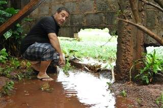 Sonoplasta mostra o tamanho da fenda aberta em muro para escoar água da chuva (Foto: Alcides Neto)