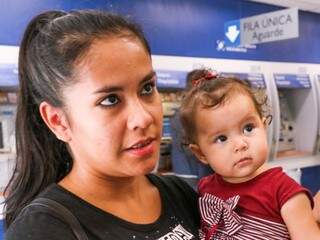 Maria Aparecida Borges, com sua filha de oito meses, foi sacar o FGTS (Foto: Henrique Kawaminami)